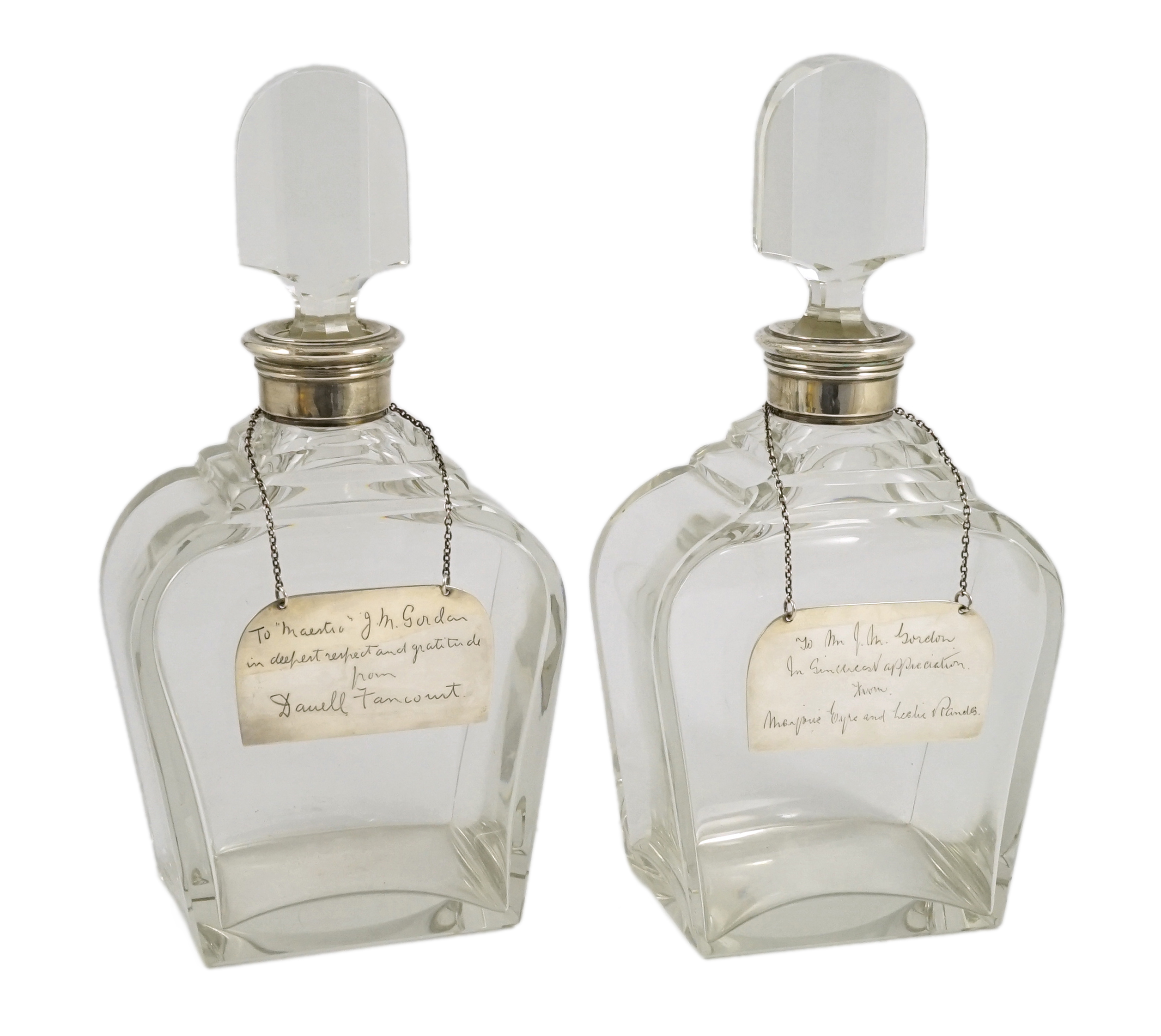 A pair of George VI silver mounted glass decanters and stoppers, by Adie Bros, presented to Mr. J.M. Gordon, to celebrate fifty five years with the D'Oyly Carte Opera Company